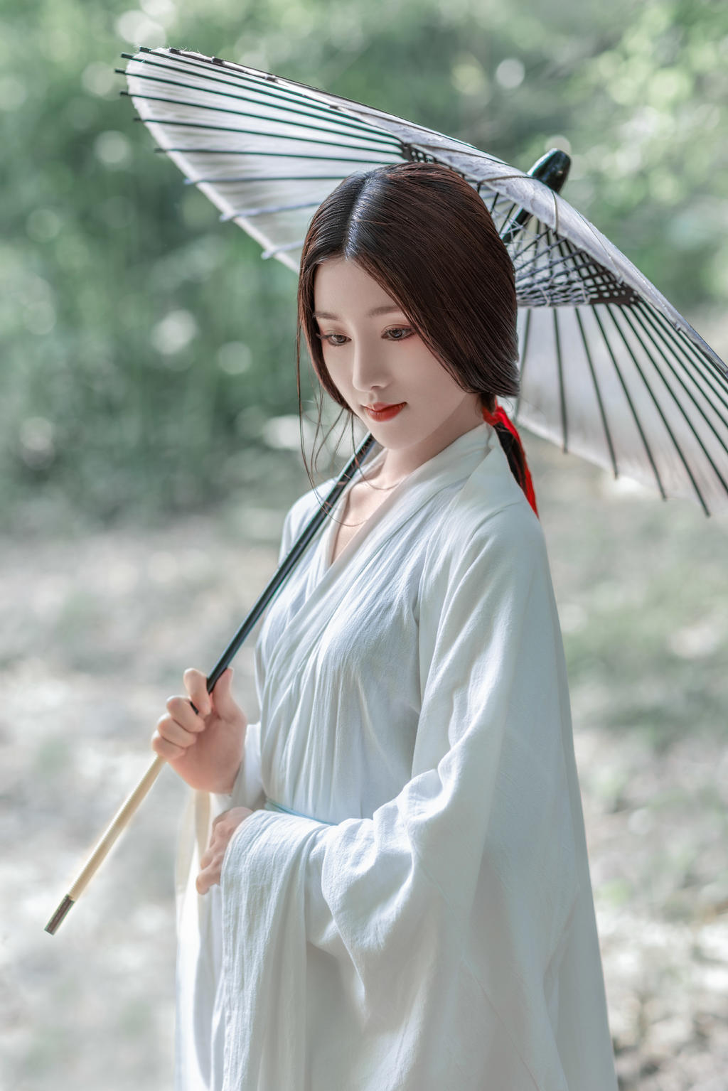 撑着油纸伞的白衣美女竹林写真
